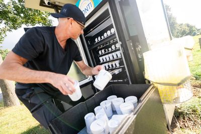 Mitarbeiter befüllt einen Conti-Eisautomaten mit frisch hergestelltem Eis